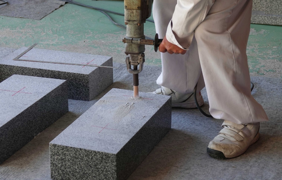 職人が石材を電動工具で加工しているようす